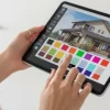 タブレットを使い、日本の住宅の外壁カラーシミュレーションを操作している手元。多彩なカラーパレットから色を選んでいる。