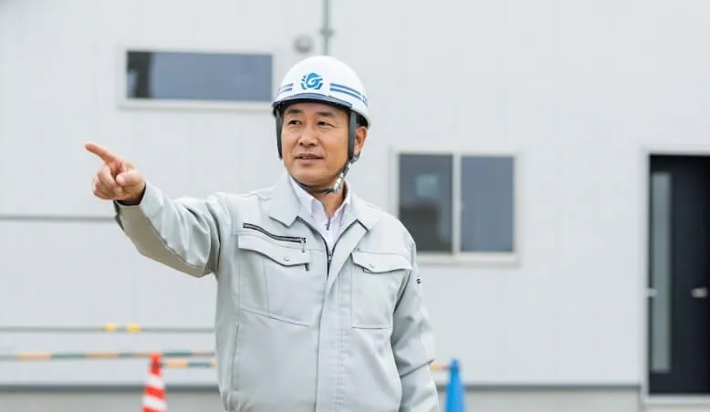 現場で自信を持って解説する、頼れる専門家である中年の日本人男性作業員