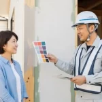 施主と現場の責任者が、外壁の色見本を見ながら穏やかに打ち合わせをしている様子