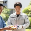 施主と業者が一緒に近隣住民へ挨拶に伺い、丁寧に品物を手渡している様子
