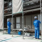 きれいに養生された住宅で、アップリメイクの職人が安全に外壁塗装の作業を進めている様子