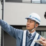 資格を持った専門家がヘーベルハウスの外壁を丁寧に診断している様子。別のスタッフがメモを取っており、信頼できるプロの仕事ぶりが伝わる