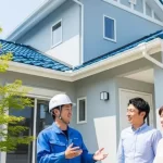 施工後の家の前で、笑顔で話す日本人スタッフと施主様ご夫婦。良好なコミュニケーションと顧客満足を表している