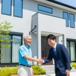 外壁塗装工事が完了した美しい大和ハウスジーヴォの住宅の前で、満足されたお客様と株式会社アップリメイクの担当者が笑顔で握手をしている