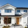 青空の下に建つ、塗装したての綺麗な外壁を持つ30坪のモダンな二階建て住宅