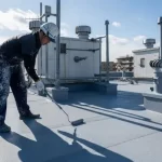 アパートの複雑な形状をした屋上で、日本の職人がローラーを使い丁寧にウレタン防水を施工している様子