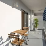 マンションの外壁塗装工事が完了し、清潔で美しく生まれ変わったベランダのワイド写真